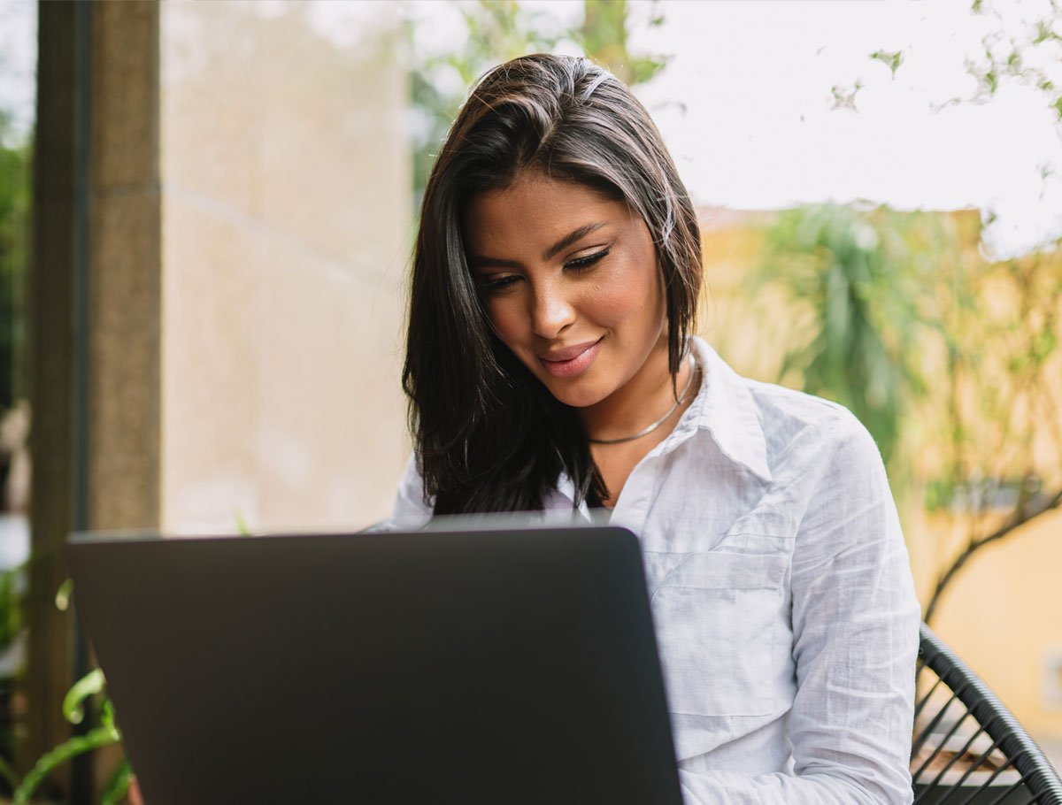 Mujer investigando las opciones de la cuenta corriente Alianza en su computadora portátil.