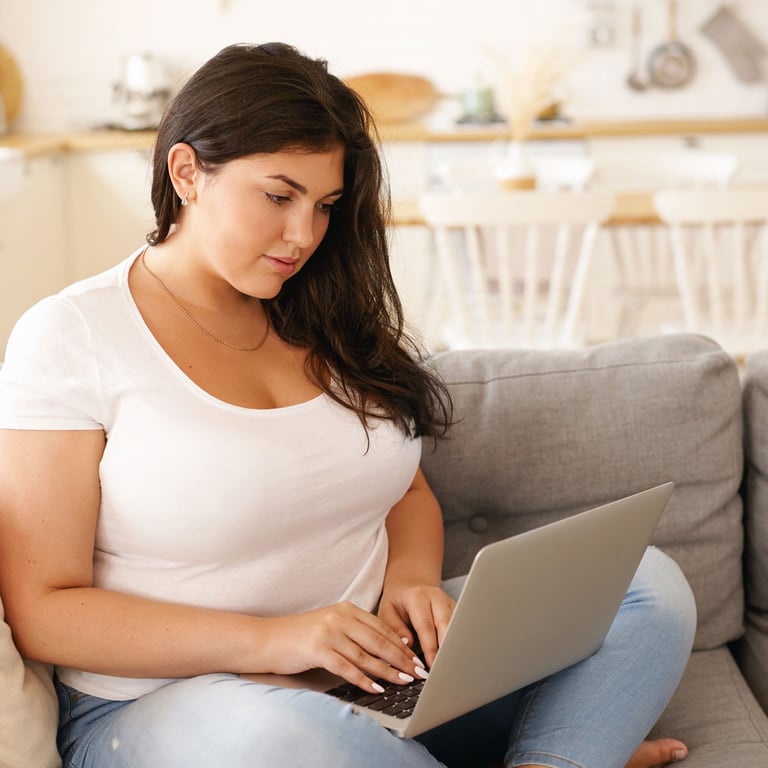 Mujer joven en su computadora portátil abriendo una cuenta corriente de Alianza en línea.
