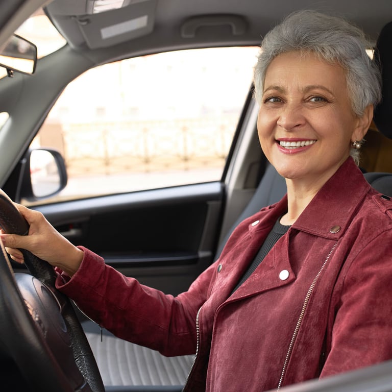 Abuela latina segura conduciendo su auto nuevo gracias a Alianza.