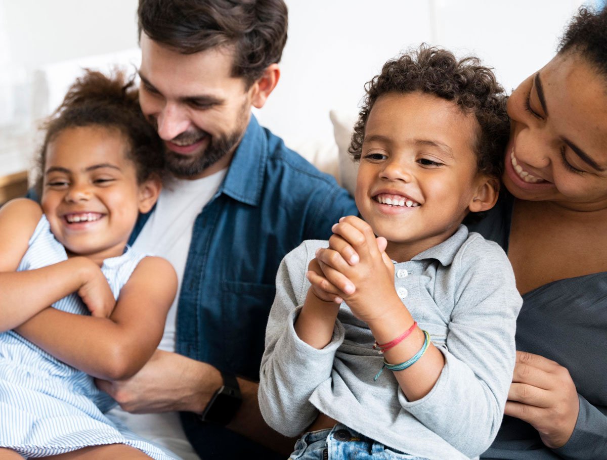 Familia sonriendo riendo juntos después de aprovechar un préstamo de construcción de crédito de Alianza.