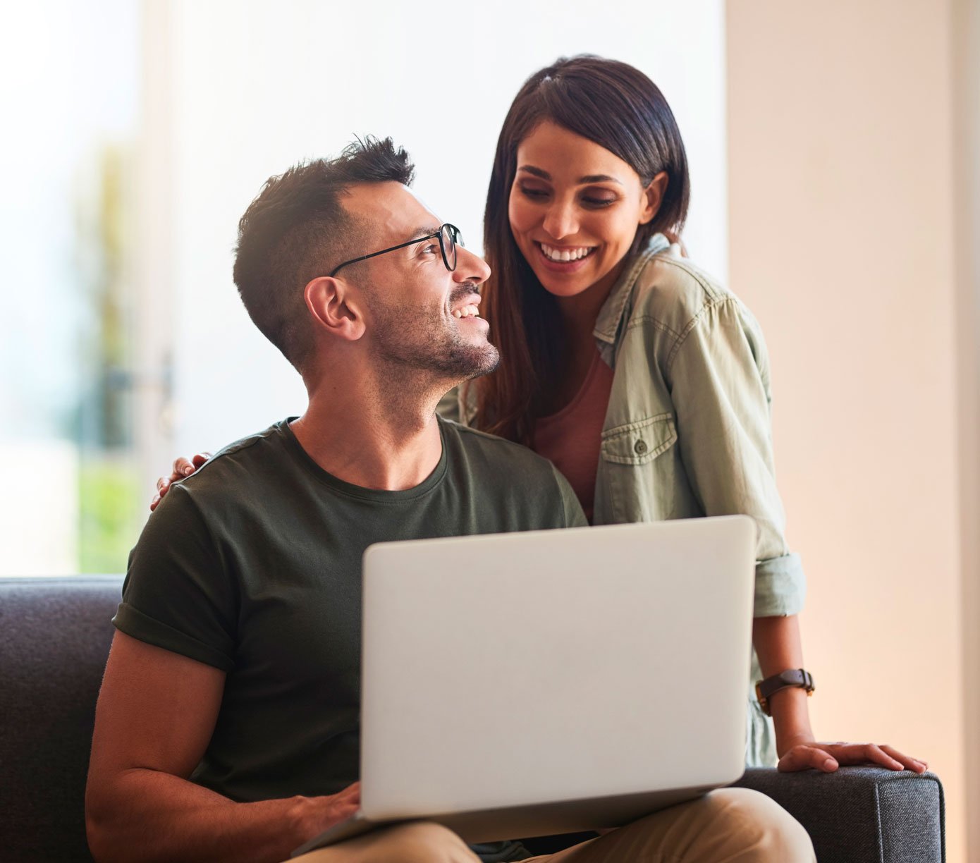 Pareja latina solicitando un préstamo para generar crédito en su computadora portátil.