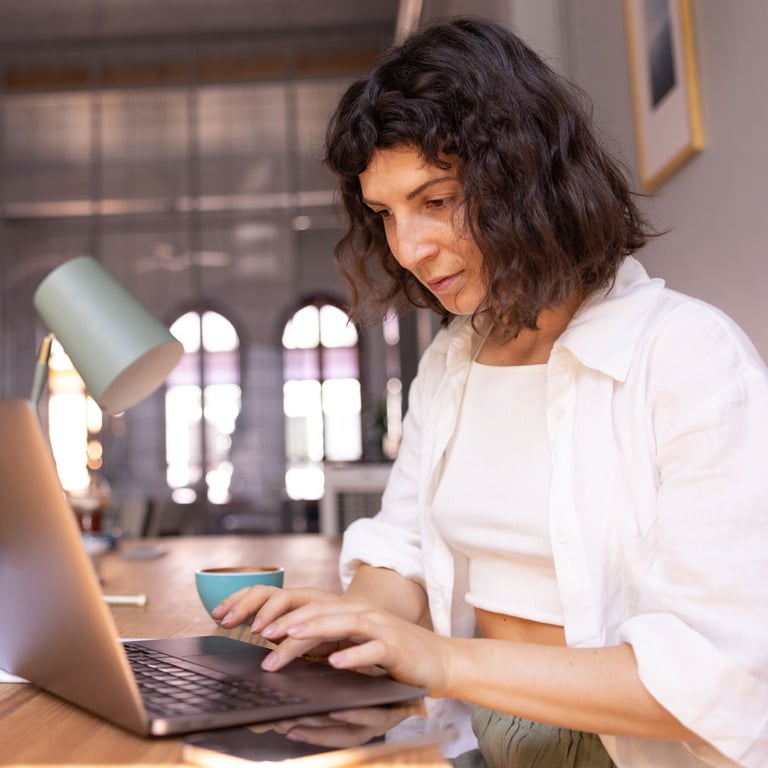 Mujer en su computadora portátil consolidando su deuda con un préstamo sobre el valor de la vivienda.