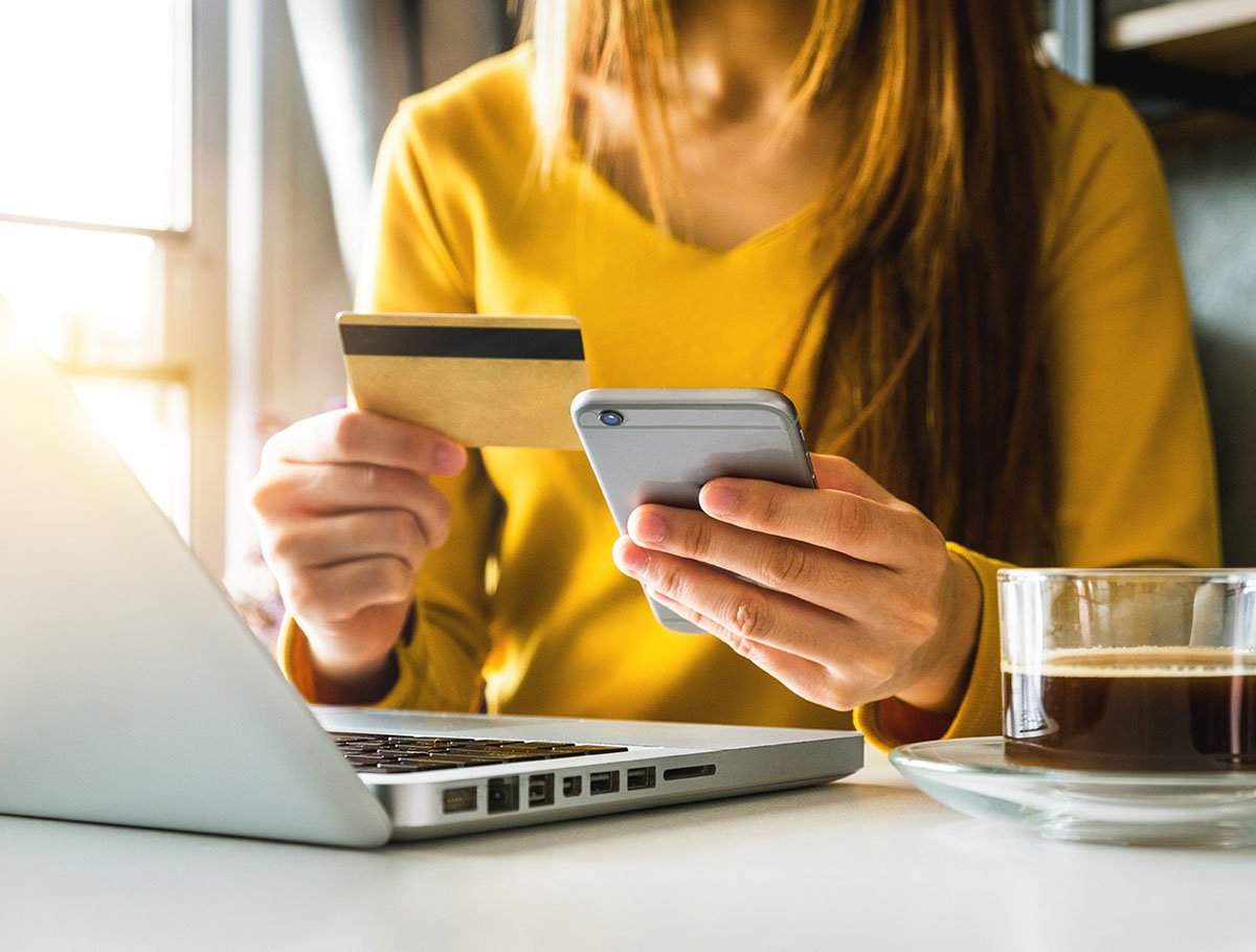 Mujer sosteniendo tarjeta de débito en cafetería