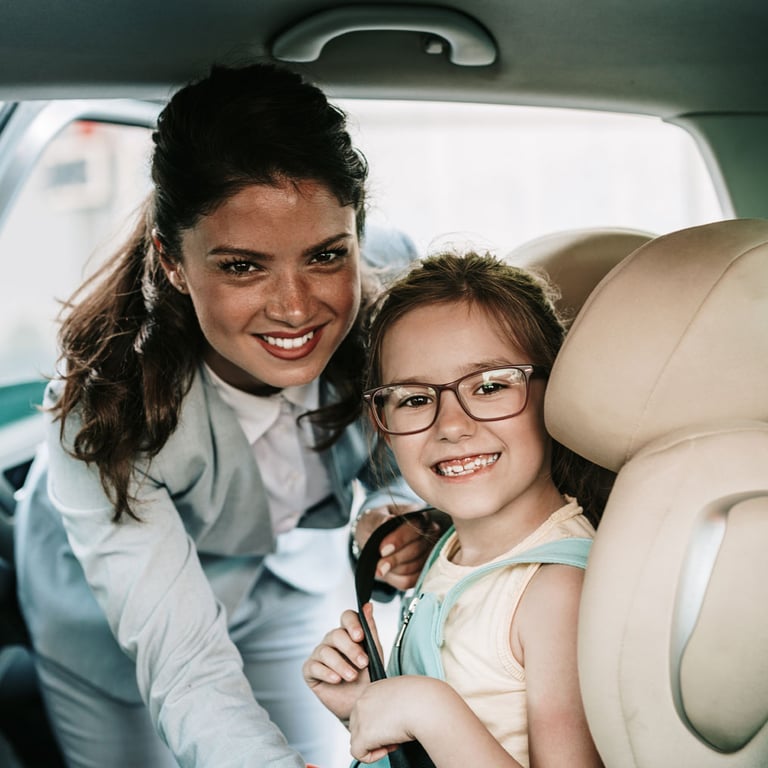 Madre abrocha a su hija en el asiento de su auto nuevo financiado por un préstamo para automóviles de Alianza.